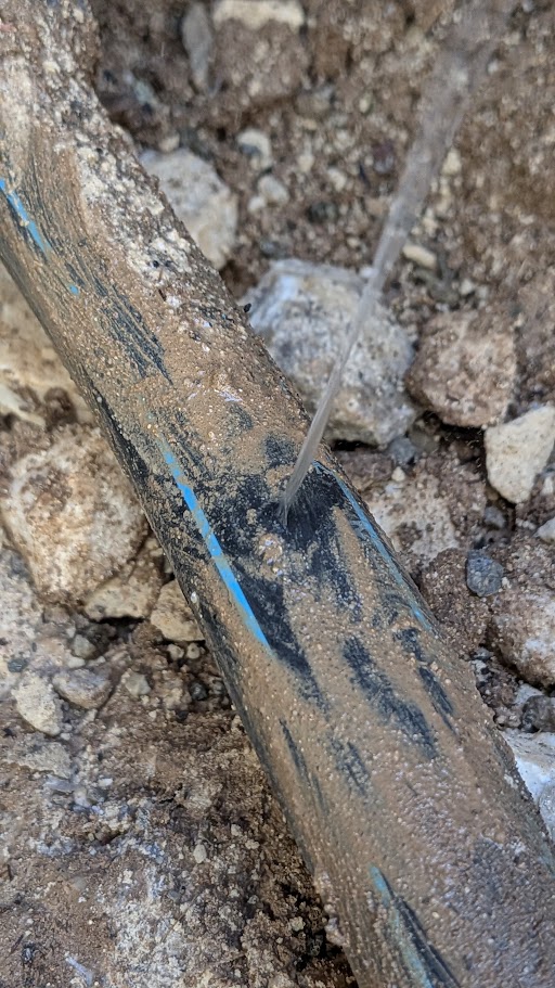 Dettaglio ravvicinato del getto d’acqua che fuoriesce dalla parete della tubazione in polietilene