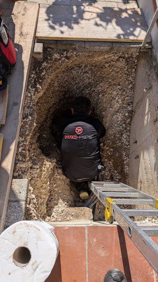 Operatore PRO-PIPE al lavoro all’interno dello scavo con una scala di accesso